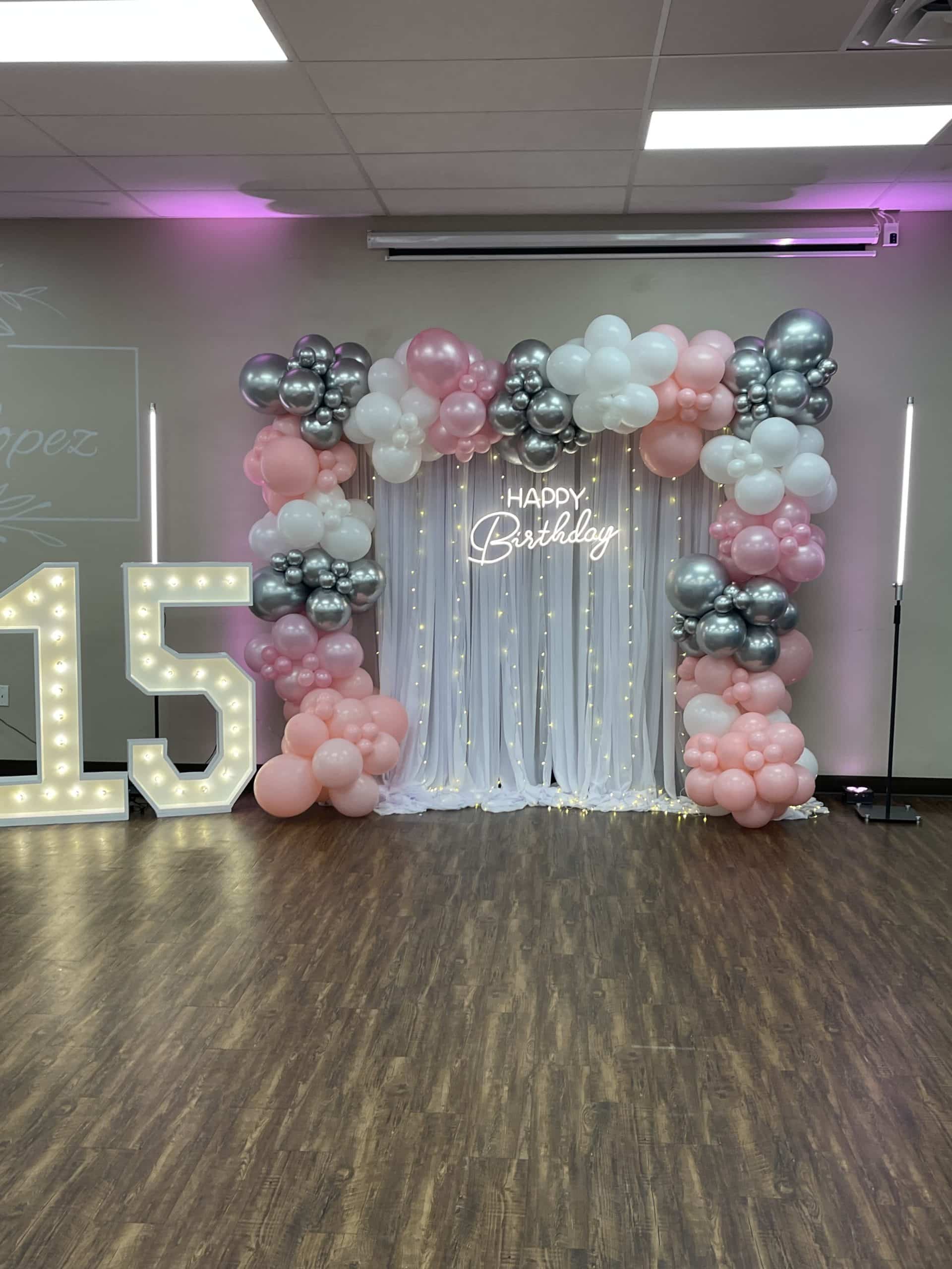 Lighted-curtain backdrop with marquee numbers for birthday event