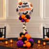 Halloween balloon table centerpiece with purple, orange, black balloons and clear stem with bats